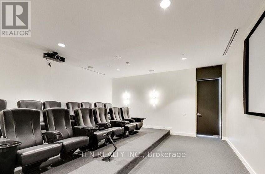 A conference room with a row of chairs and a projector screen.