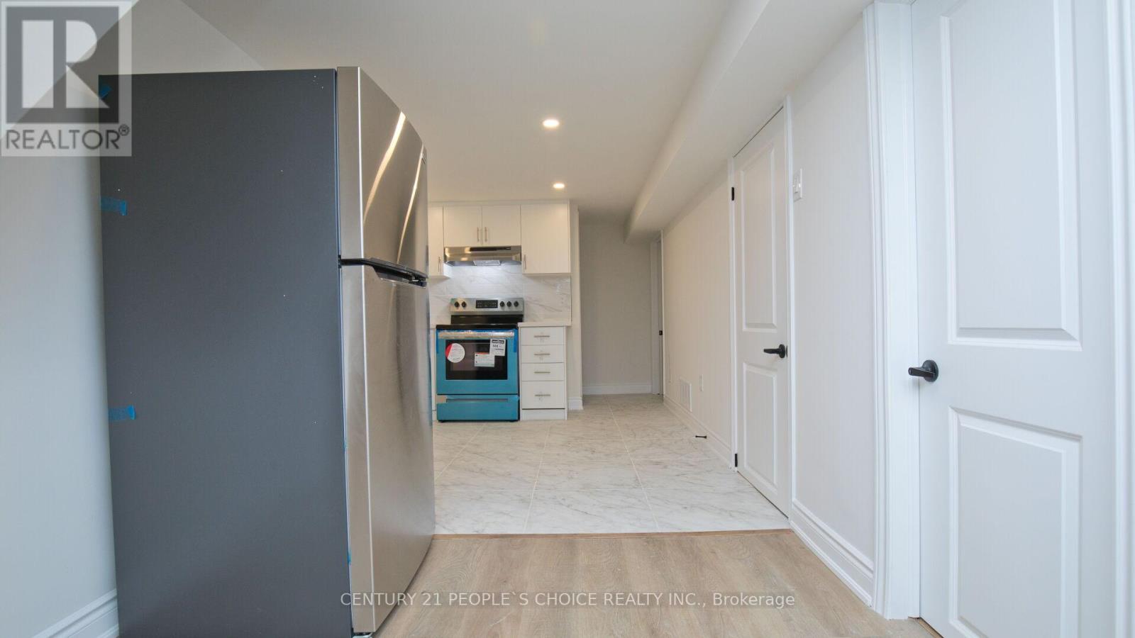 A kitchen with a refrigerator and a sink.