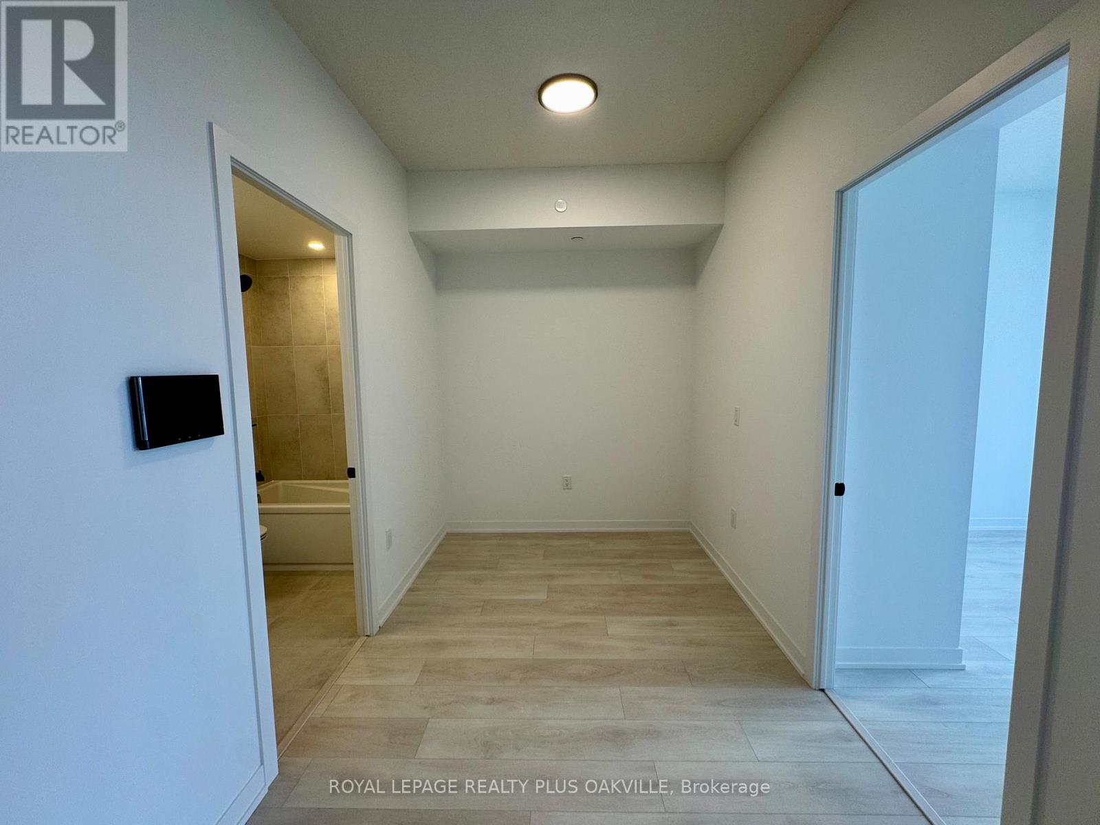 A spacious room with a doorway leading to another room.