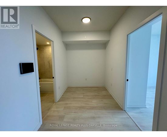 A spacious room with a doorway leading to another room.