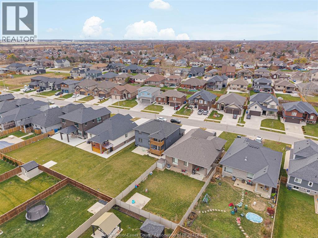 A bird's eye view of a residential neighborhood with houses and a swimming pool.