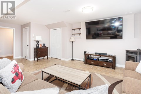 A living room with a couch, coffee table, and a television mounted on the wall.