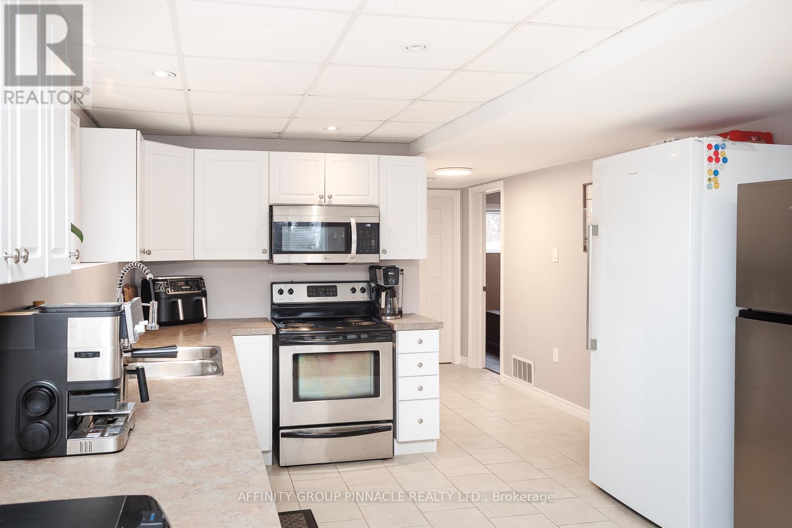 A modern kitchen with white cabinets and stainless steel appliances.