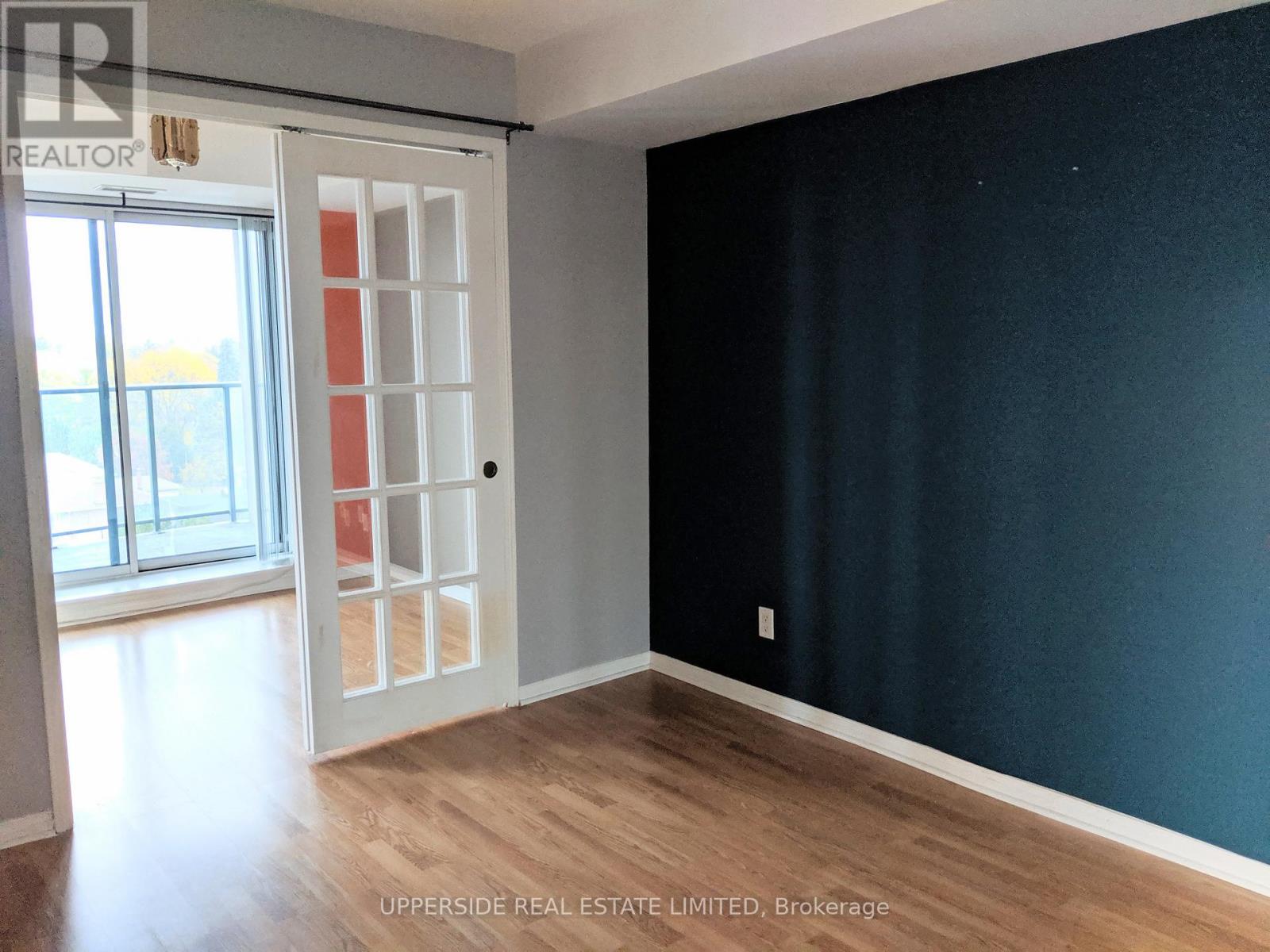 A room with a dark blue wall and a white door.