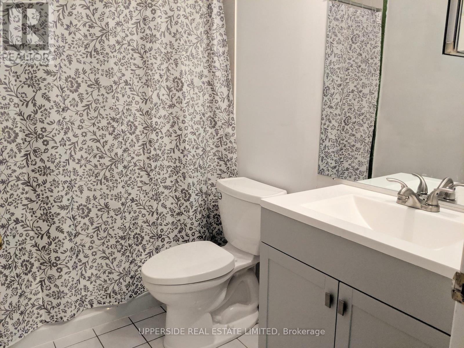 A white toilet sits next to a sink in a bathroom.