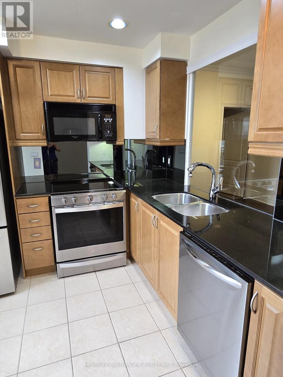 A kitchen with wooden cabinets and black countertops.