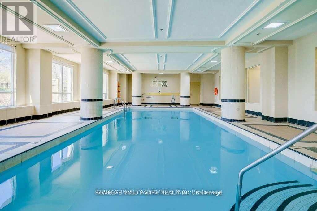 A large indoor swimming pool with a blue tinted water.