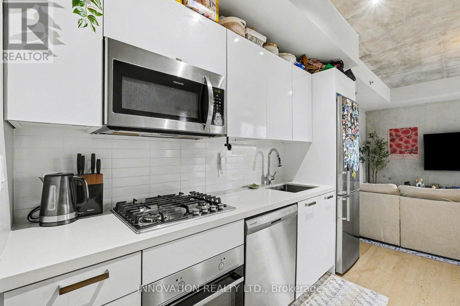 A modern kitchen with white cabinets and stainless steel appliances.