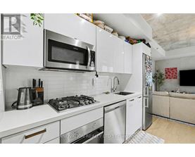 A modern kitchen with white cabinets and stainless steel appliances.