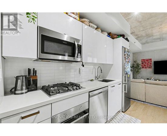 A modern kitchen with white cabinets and stainless steel appliances.