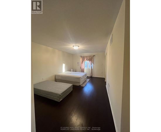 A bedroom with two beds and a window with curtains.