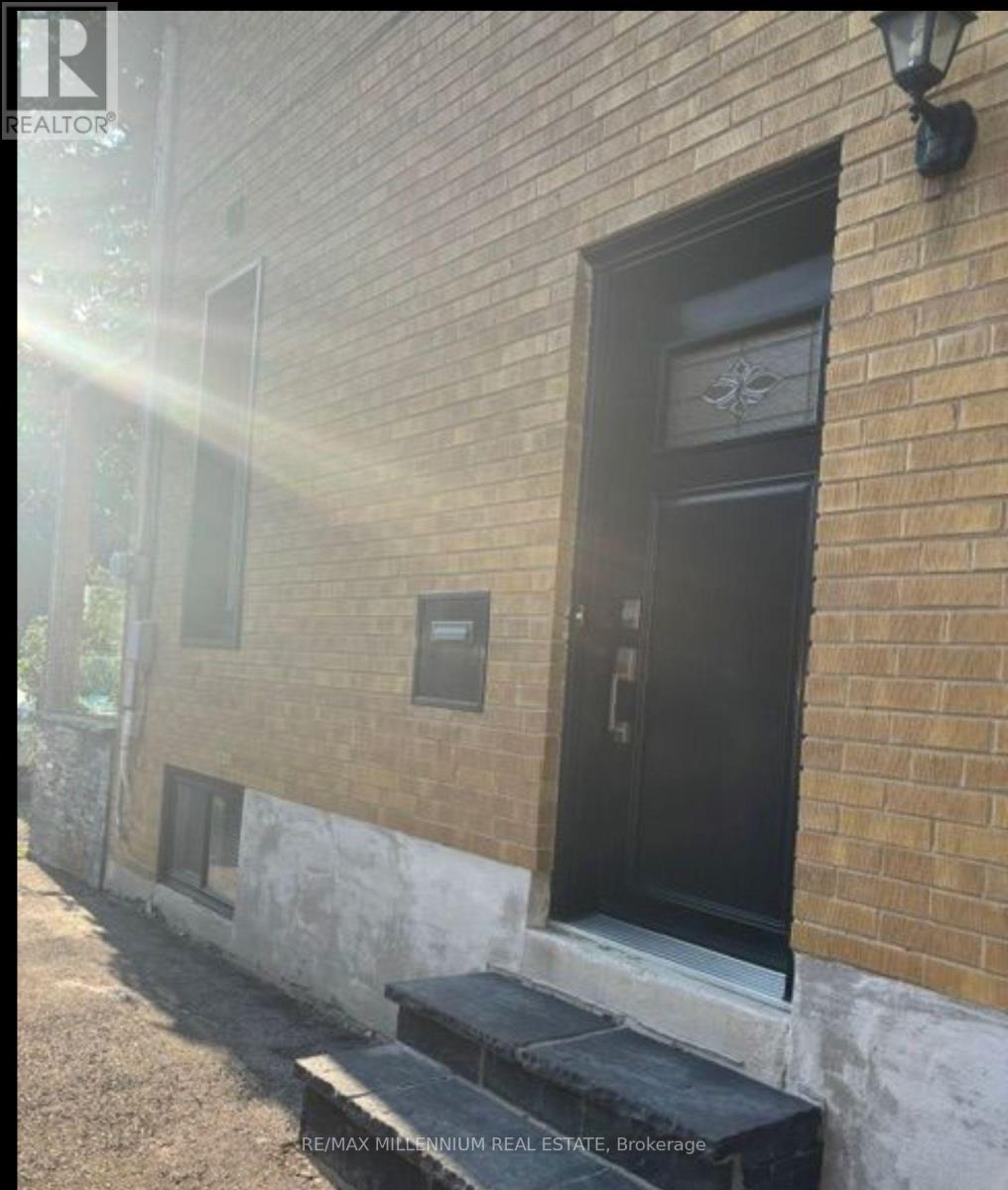 A black door with a glass window is on a brick building.