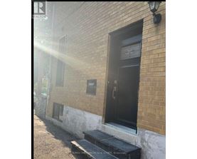 A black door with a glass window is on a brick building.