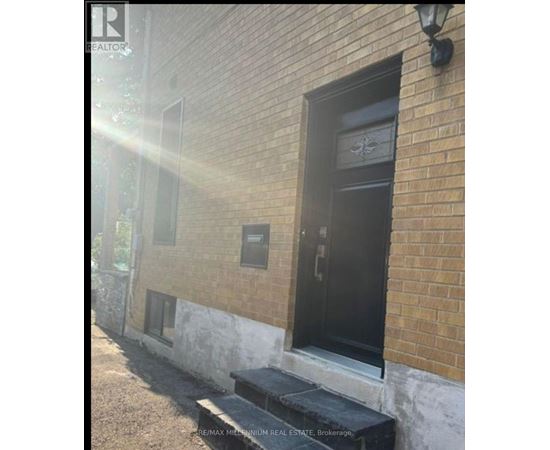 A black door with a glass window is on a brick building.
