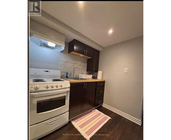 A kitchen with a white stove and black cabinets.