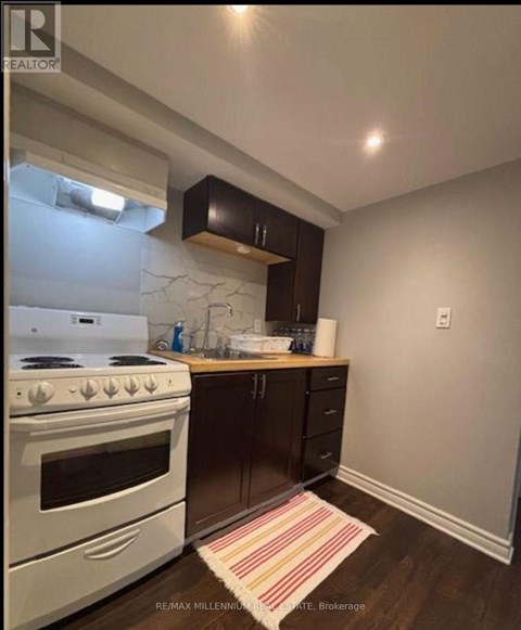 A kitchen with a white stove and black cabinets.