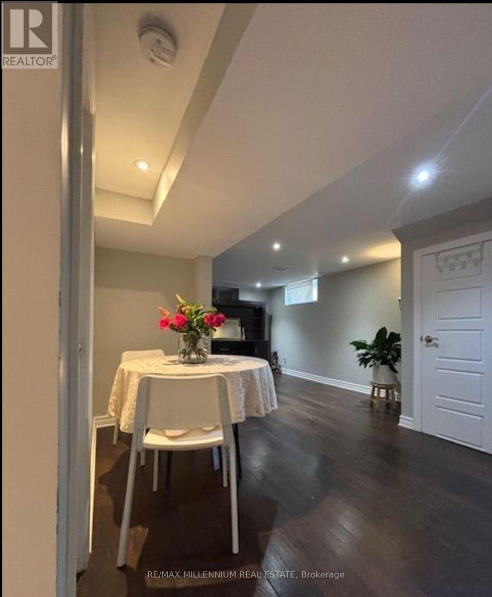 A dining room with a table set for two and a vase of flowers.