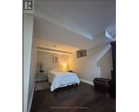 A bedroom with a bed, nightstand, and chair.