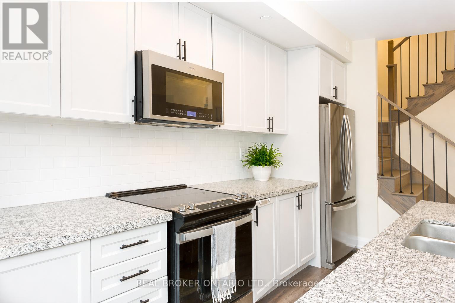 A kitchen with a black stove top oven and a black microwave above it.