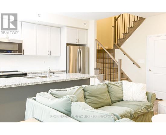 A living room with a couch and a staircase.