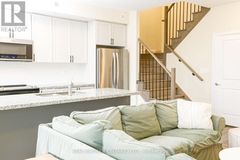 A living room with a couch and a staircase.