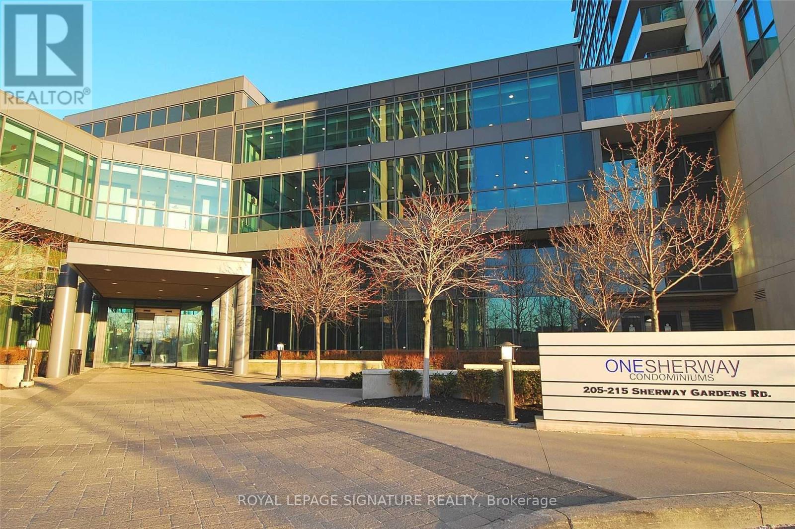 A modern building with glass windows and a sign that reads "ONE SHERWAY".
