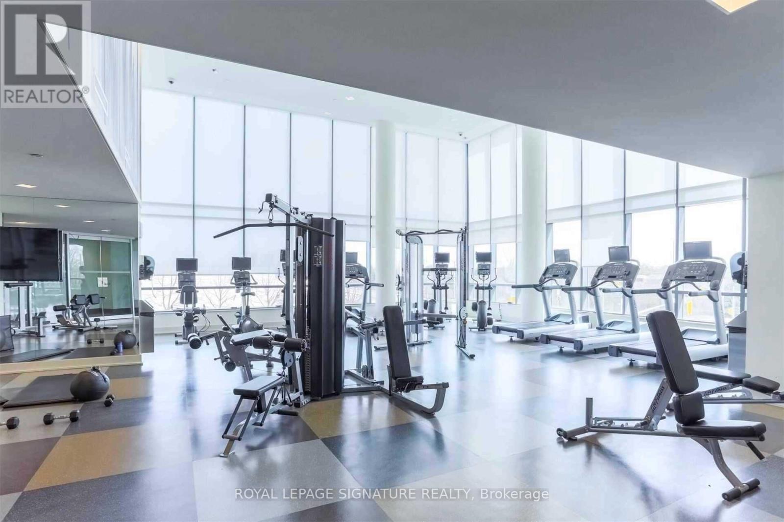A gym with a variety of equipment including treadmills, weights, and exercise machines.