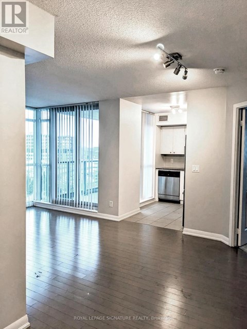 A well lit kitchen area with a refrigerator, microwave and oven.