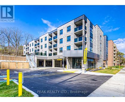 A modern apartment building with a parking lot in front.