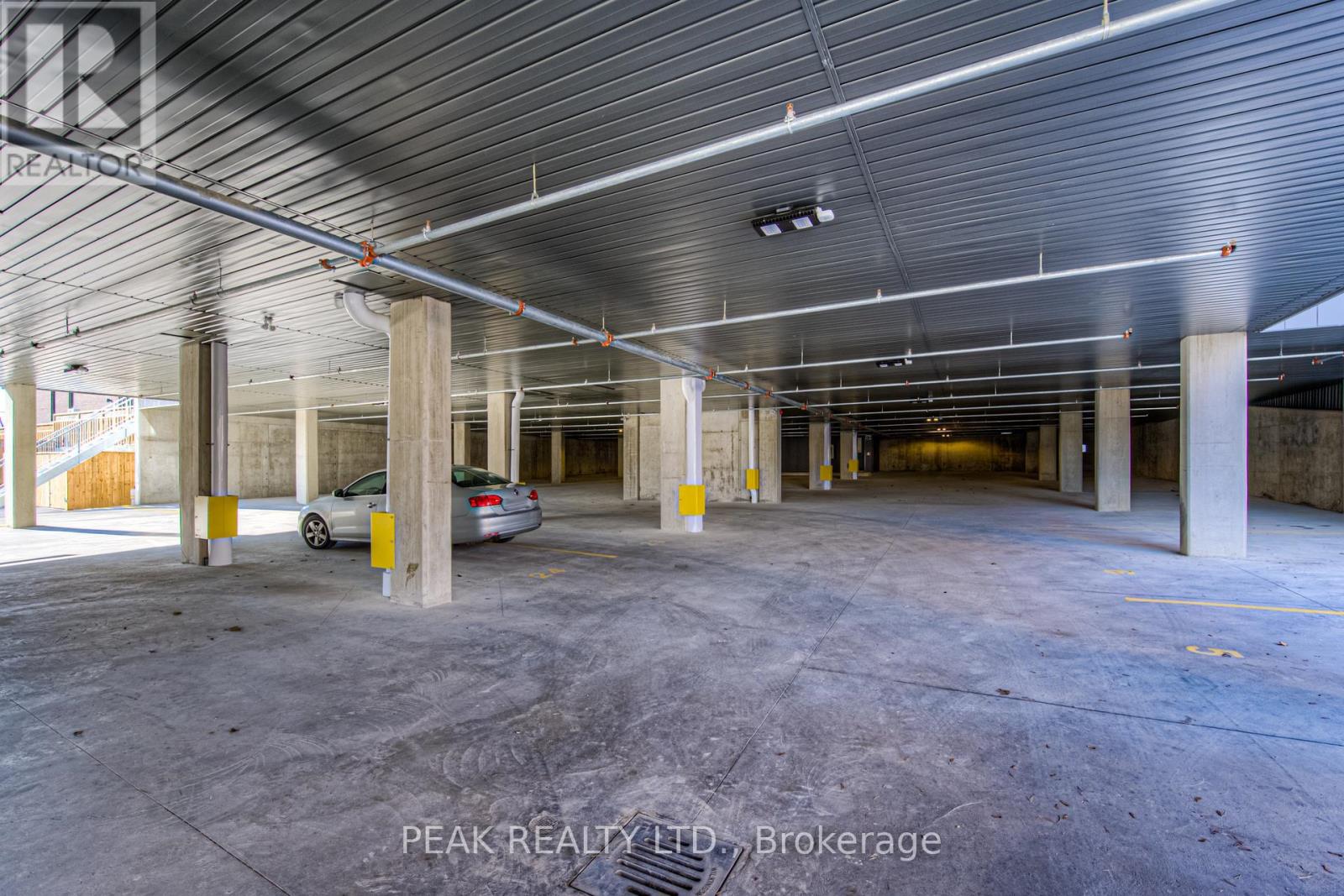 A spacious, empty parking garage with a car parked in the middle.