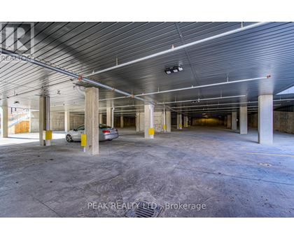 A spacious, empty parking garage with a car parked in the middle.