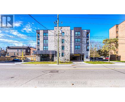 A building with the sign "Peak Realty LTD Brokerage" in front of it.