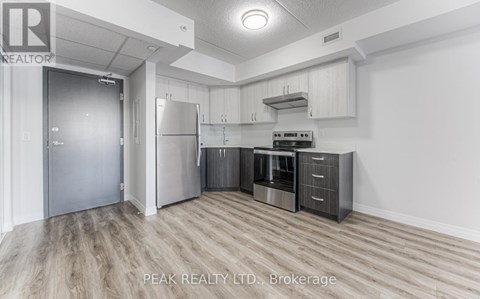 A kitchen with a refrigerator, stove, and oven.