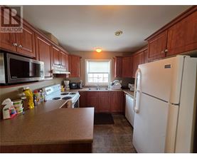 A kitchen with brown cabinets and a white refrigerator.