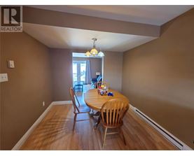 A dining room with a wooden table and chairs.