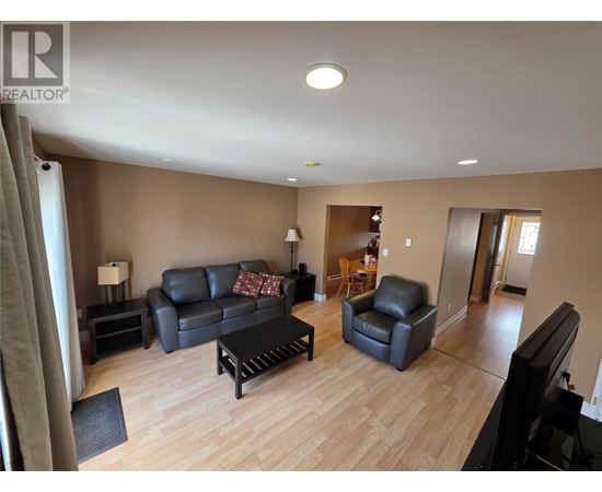 A living room with a black leather couch and a wooden coffee table.
