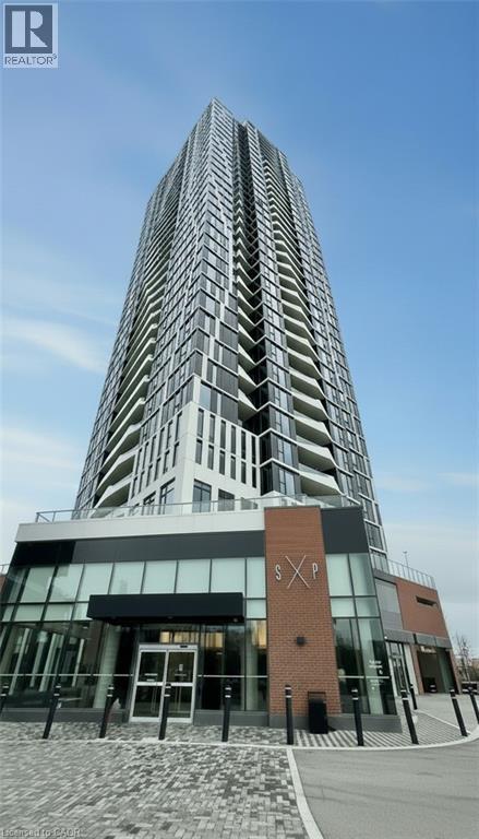 A tall building with a glass facade and a brick entrance.