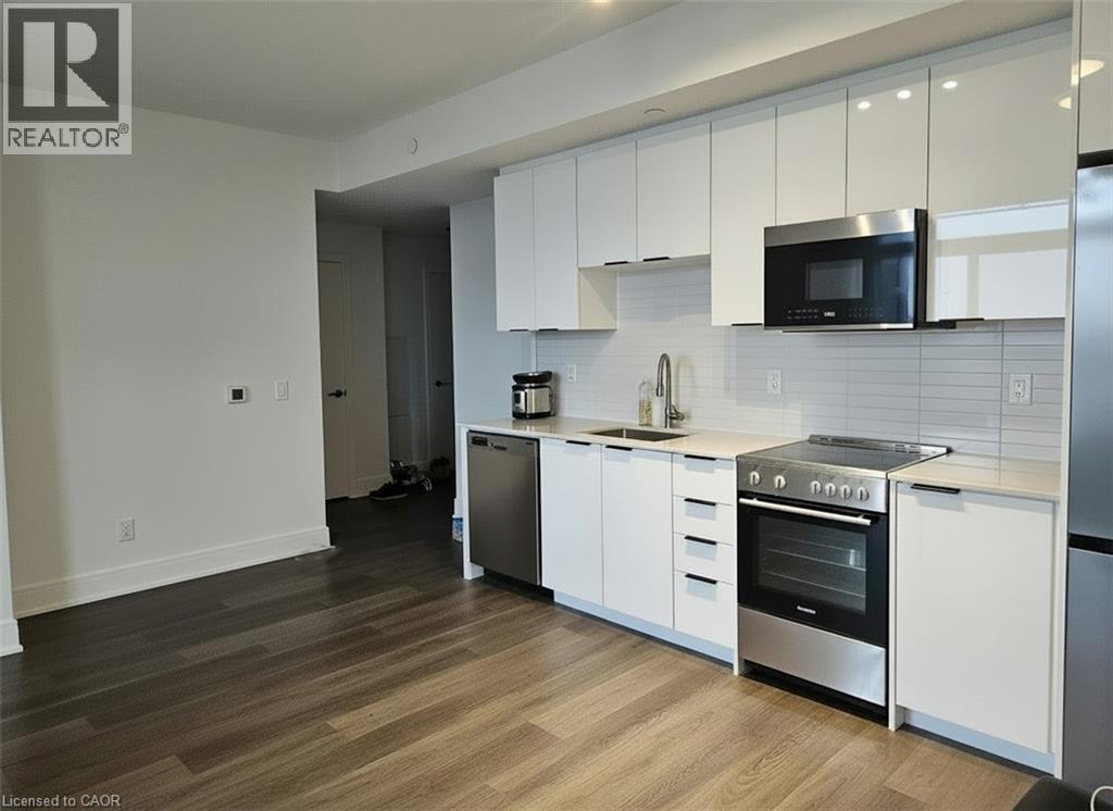 A modern kitchen with white cabinets and stainless steel appliances.