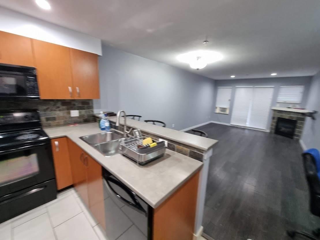 A kitchen with a black stove top oven and a black dishwasher.