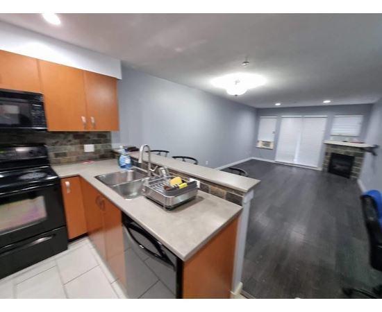 A kitchen with a black stove top oven and a black dishwasher.