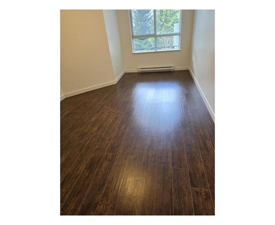 A room with wooden flooring and a window.
