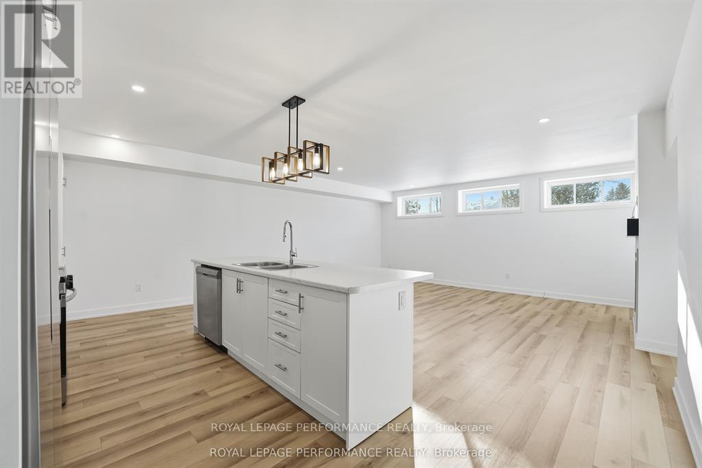 A kitchen with white cabinets and a wooden floor.