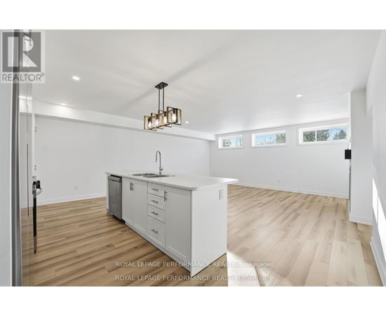 A kitchen with white cabinets and a wooden floor.