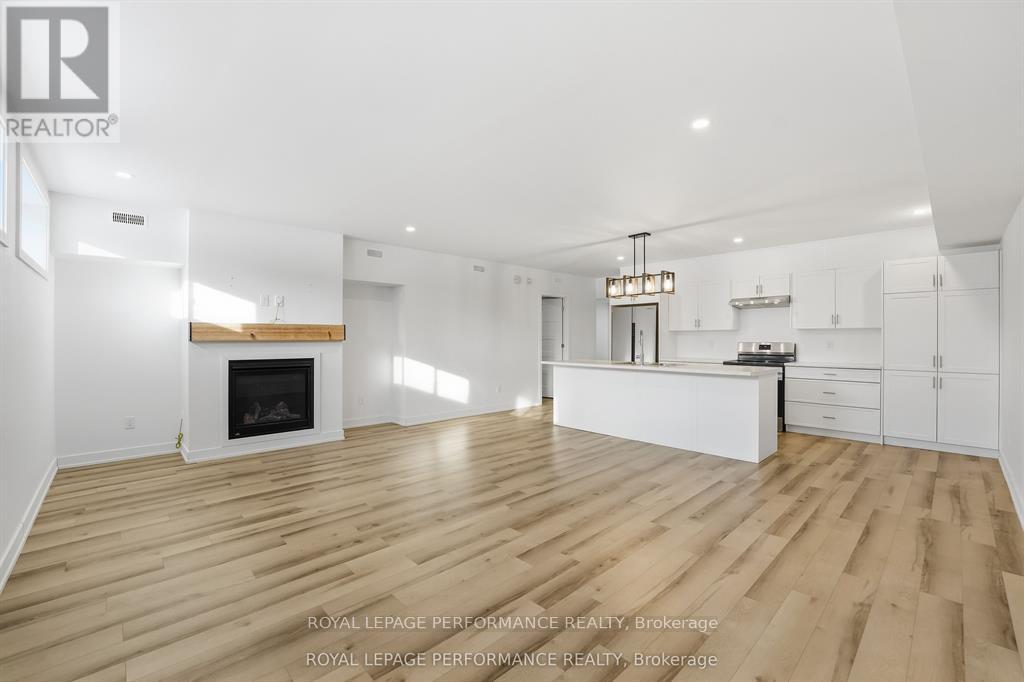 A spacious living room with a fireplace and hardwood floors.
