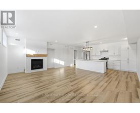 A spacious living room with a fireplace and hardwood floors.