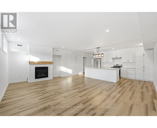 A spacious living room with a fireplace and hardwood floors.