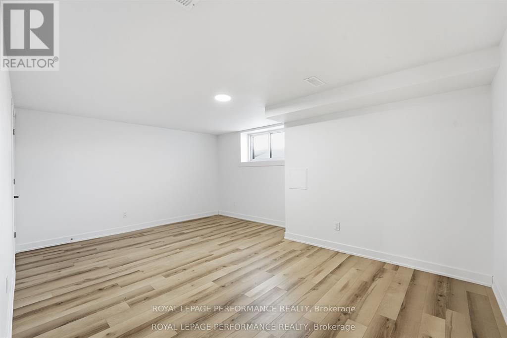 A spacious room with wooden flooring and white walls.