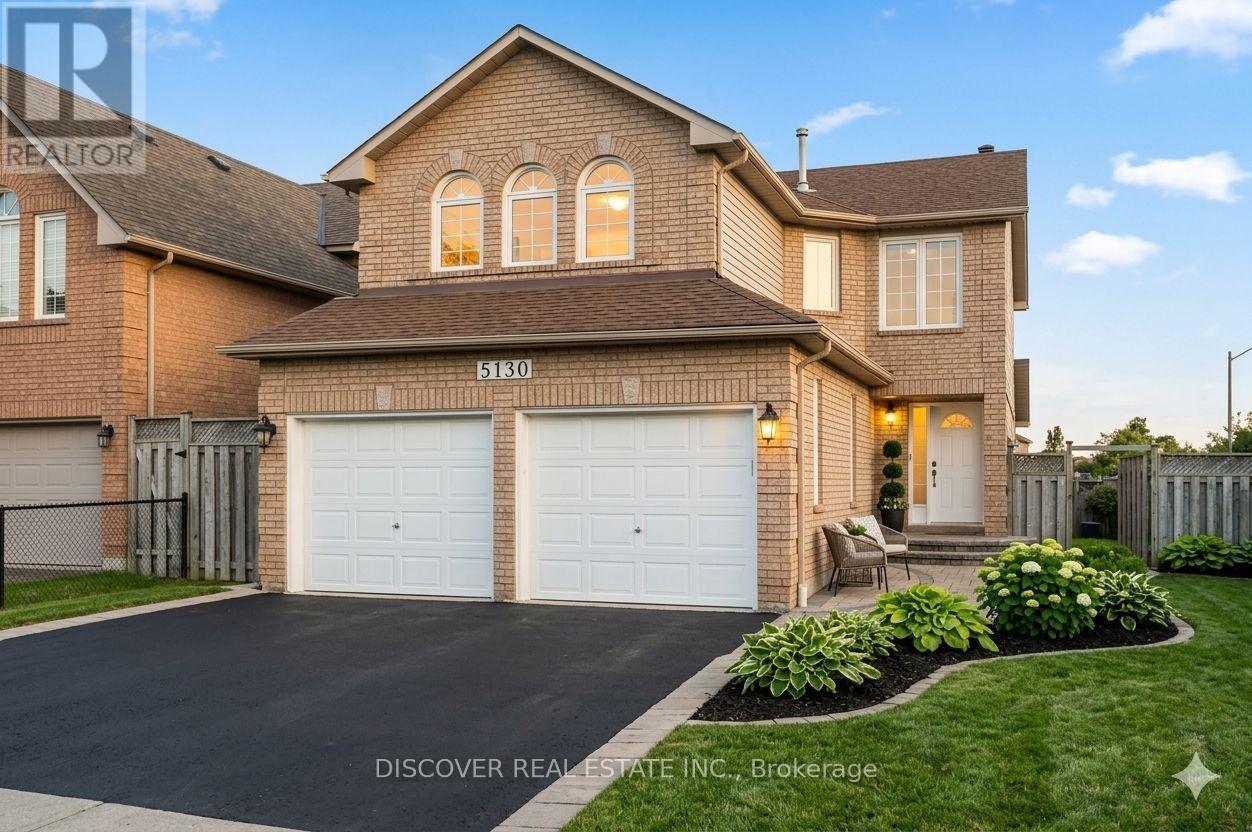 A house with a driveway and garage doors is for sale.
