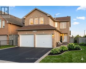 A house with a driveway and garage doors is for sale.
