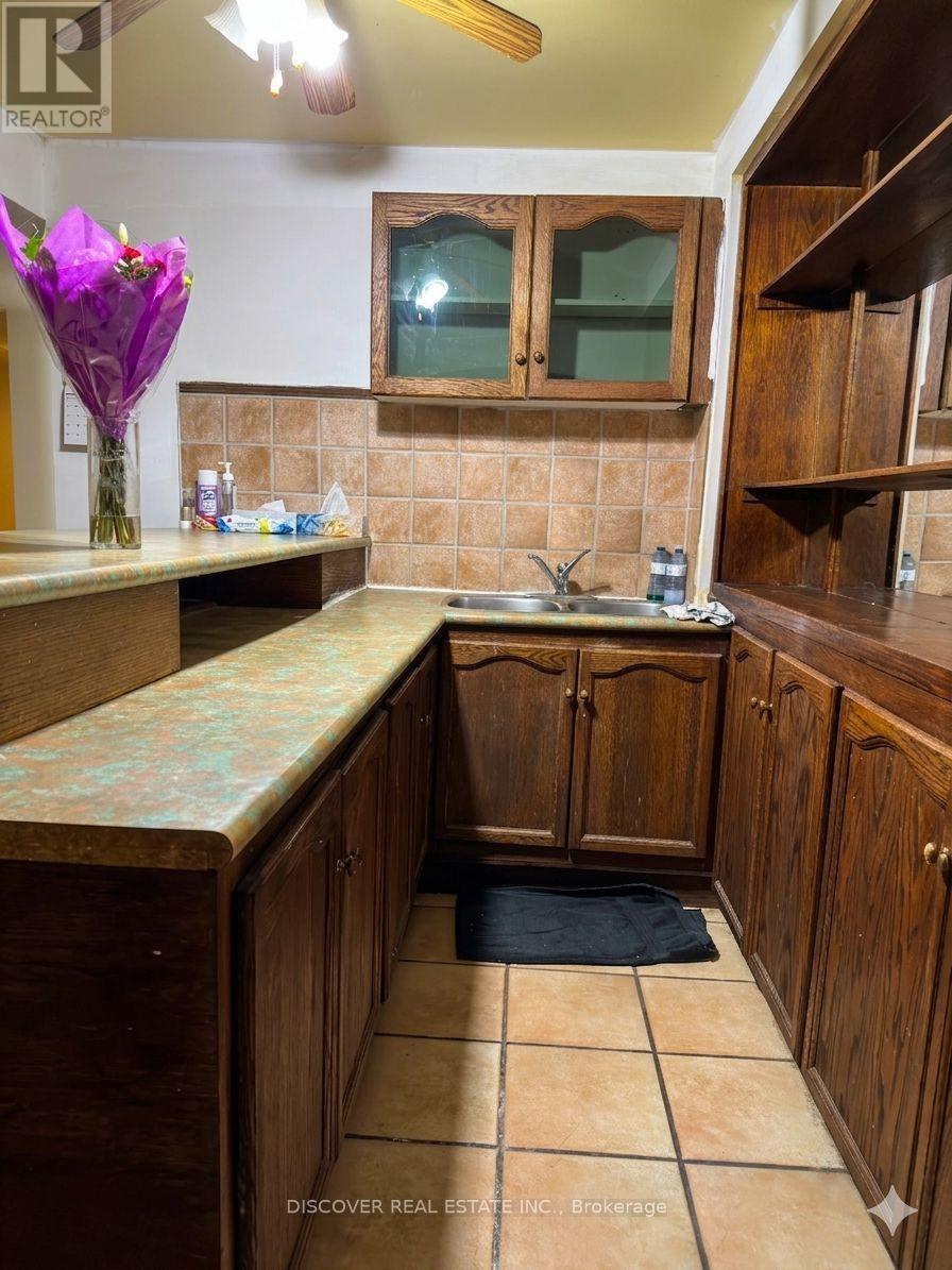 A kitchen with wooden cabinets and a tiled floor.